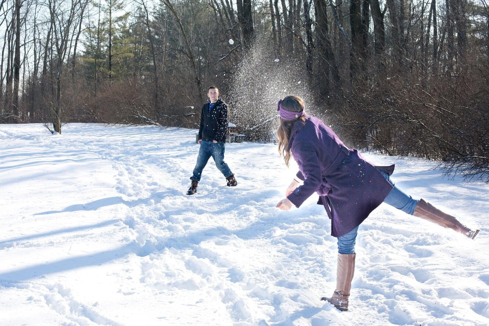 En campagne, un couple en tracances s'amuse à se lancer des balles de neige hors des heures de travail